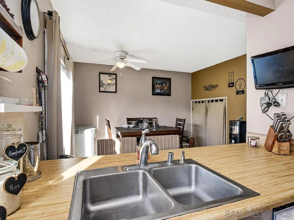 8022 Winter Gardens Boulevard, Unit E El Cajon, CA 92021 - Photo 14 of 30 a kitchen with a sink a flat screen tv and a view of living room