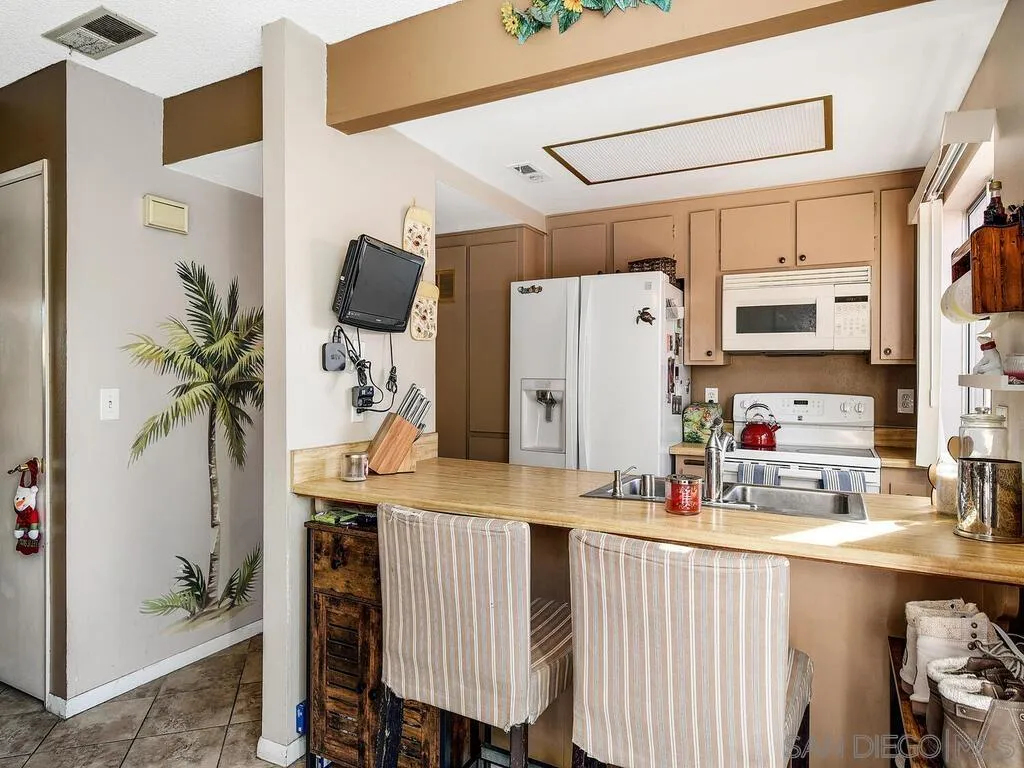 8022 Winter Gardens Boulevard, Unit E El Cajon, CA 92021 - Photo 15 of 30 a kitchen with stainless steel appliances a refrigerator and a table