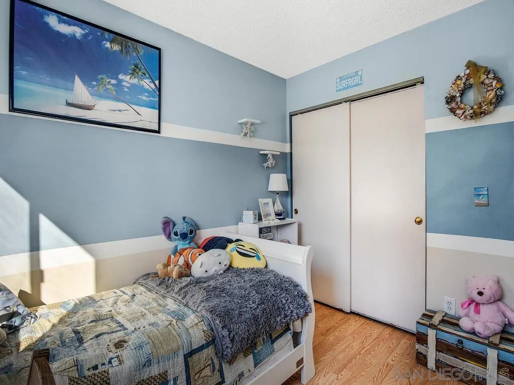 8022 Winter Gardens Boulevard, Unit E El Cajon, CA 92021 - Photo 19 of 30 a bedroom with a bed and wooden floor