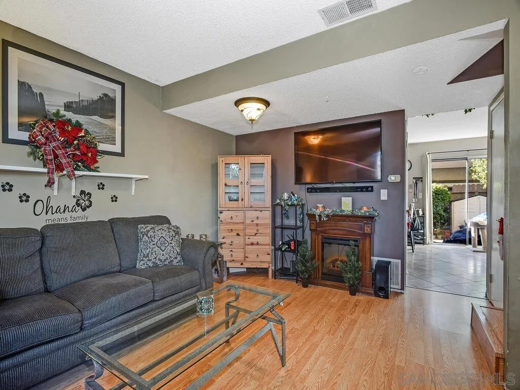 8022 Winter Gardens Boulevard, Unit E El Cajon, CA 92021 - Photo 6 of 30 a living room with fireplace furniture and a flat screen tv