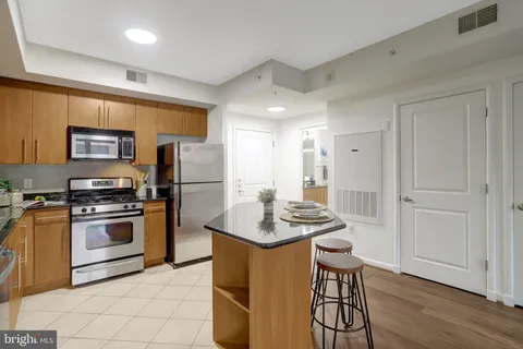 a kitchen with stainless steel appliances granite countertop a stove refrigerator and a sink