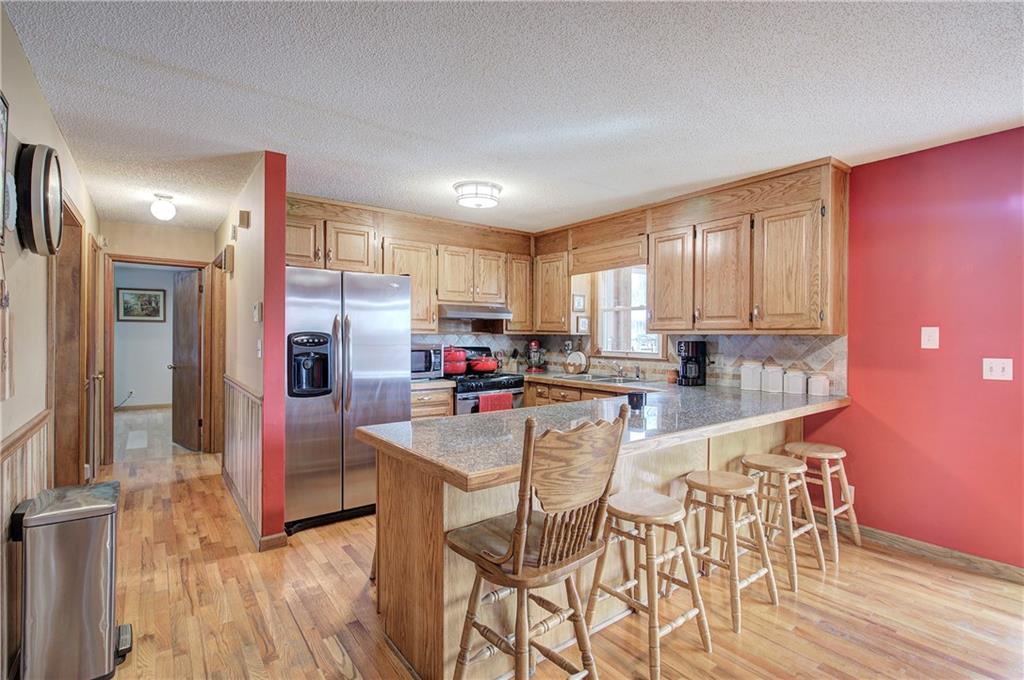 452 Terry White Road Aragon, GA 30104 - Photo 30 of 55 a kitchen with stainless steel appliances kitchen island granite countertop a refrigerator a stove a microwave oven with a dining table and chairs with wooden floor