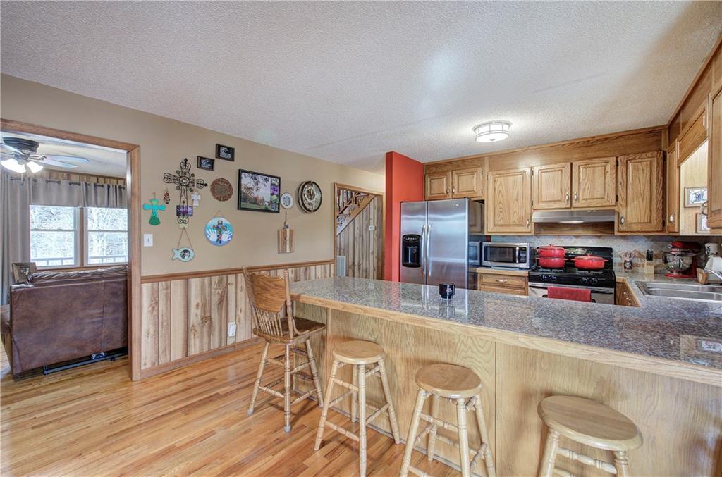 452 Terry White Road Aragon, GA 30104 - Photo 33 of 55 a kitchen with stainless steel appliances granite countertop a refrigerator a stove top oven a sink dishwasher and wooden cabinets with wooden floor