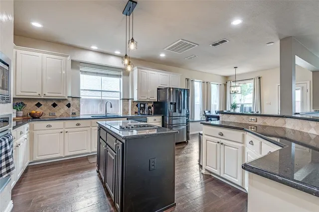 a kitchen with stainless steel appliances granite countertop a sink stove and cabinets
