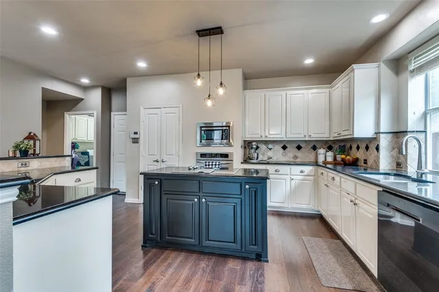 a kitchen with stainless steel appliances granite countertop wooden cabinets sink and stove