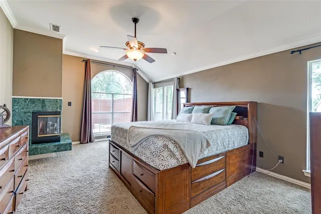 a spacious bedroom with a bed a dresser next to a window