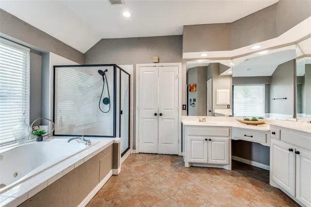 a bathroom with a granite countertop tub a sink and a shower
