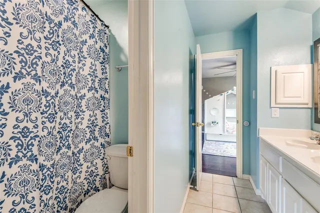 a bathroom with a granite countertop toilet and a shower