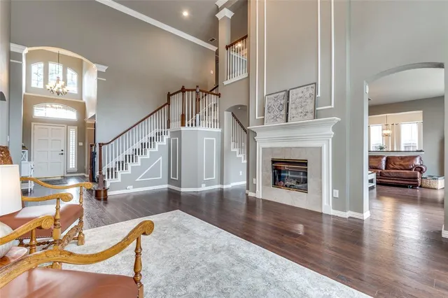 a view of a livingroom with furniture a fireplace wooden floor and windows