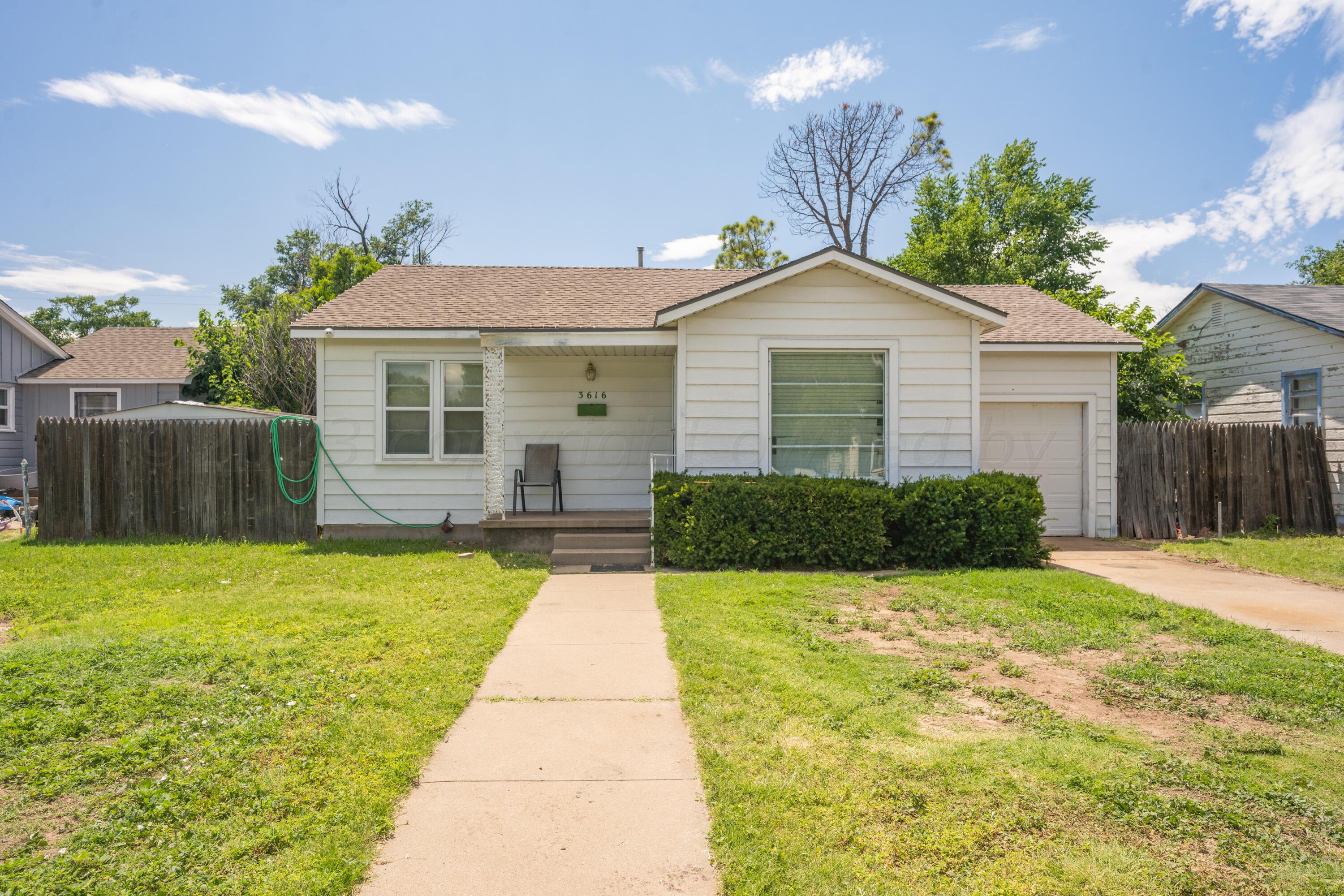 3616 South Travis Street Amarillo, TX 79110 - Photo 1 of 26 a front view of a house with a yard