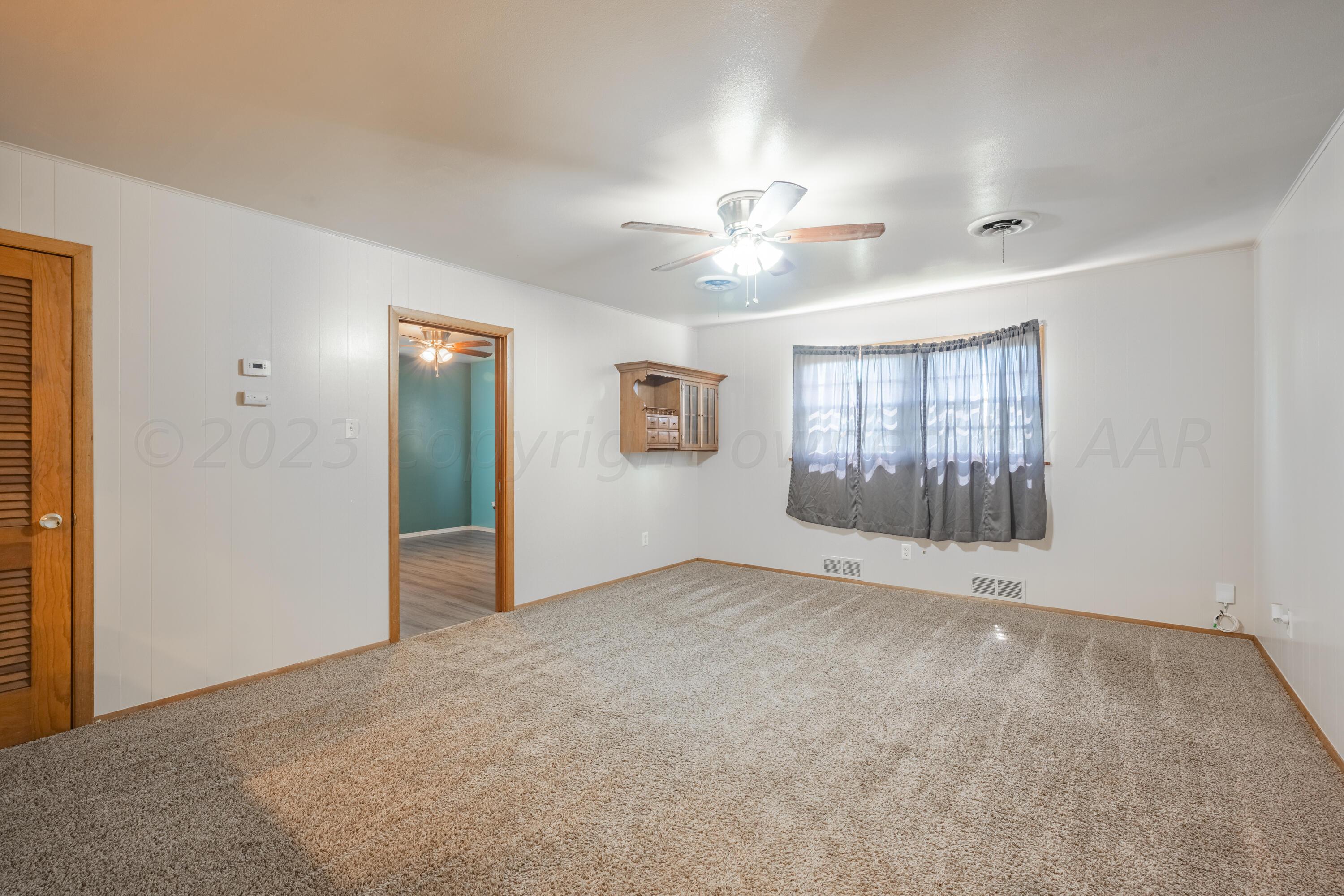 3616 South Travis Street Amarillo, TX 79110 - Photo 15 of 26 an empty room with windows and ceiling fan