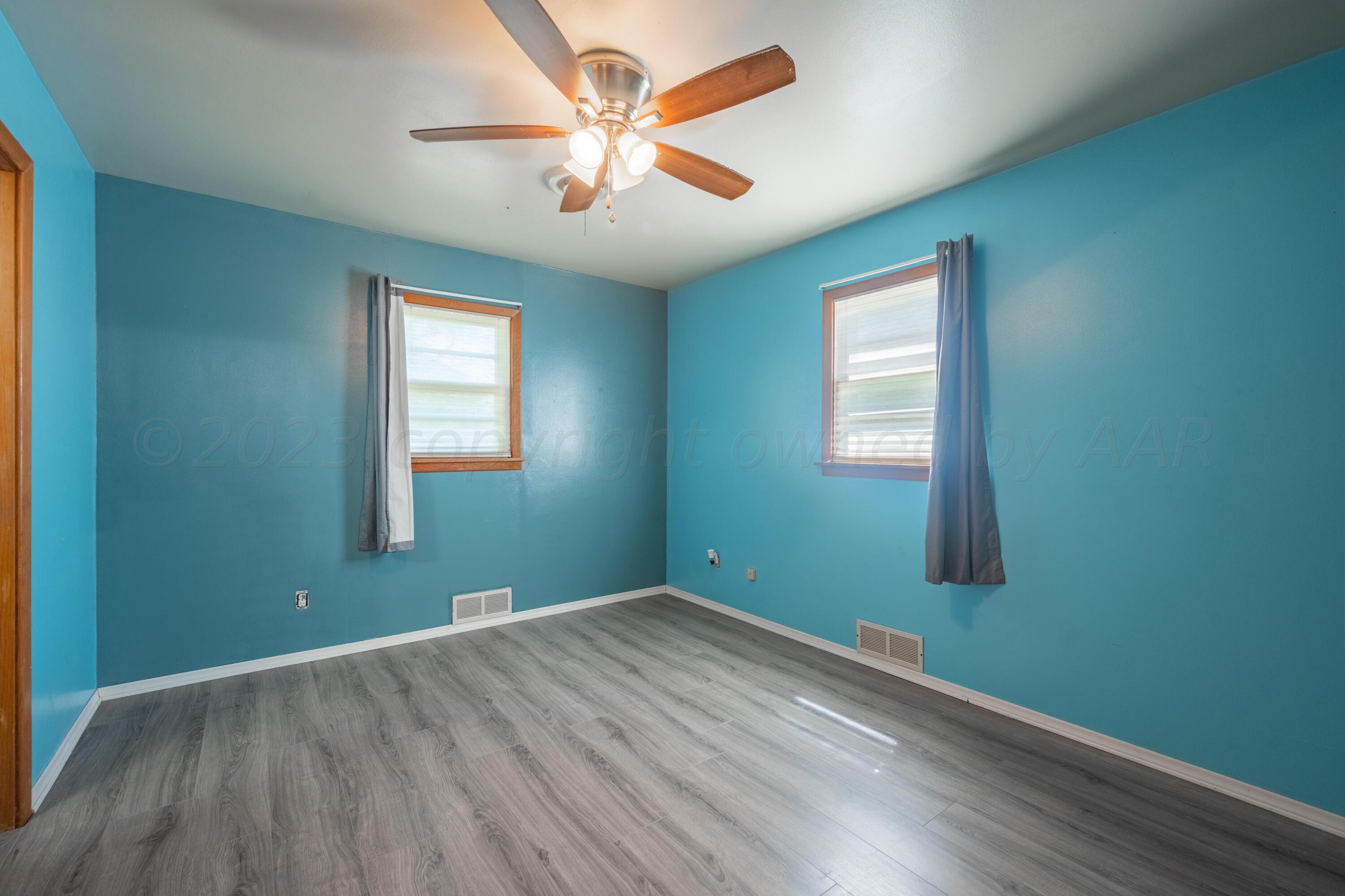 3616 South Travis Street Amarillo, TX 79110 - Photo 19 of 26 wooden floor in an empty room with a window