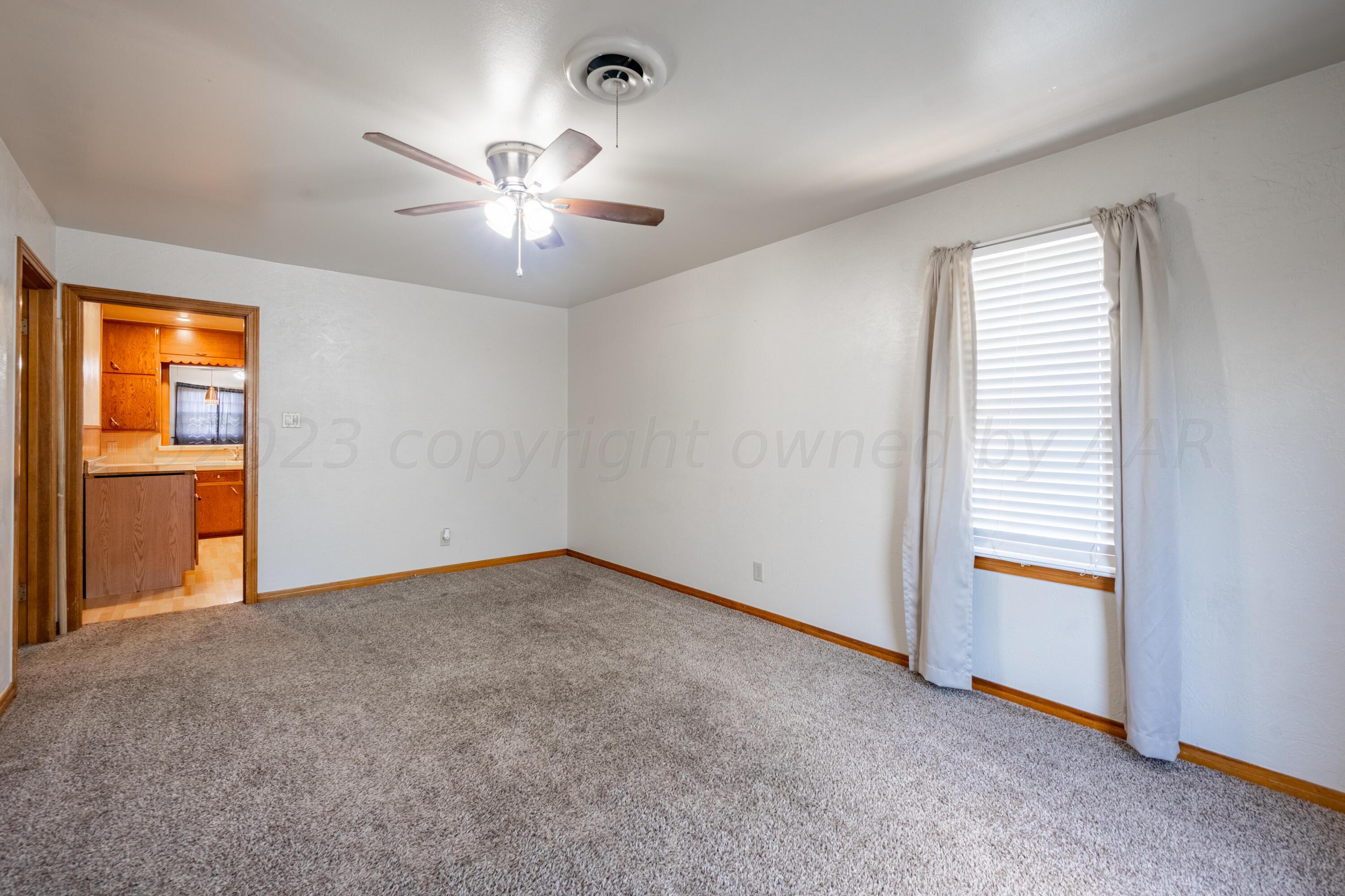 3616 South Travis Street Amarillo, TX 79110 - Photo 4 of 26 an empty room with chandelier fan and windows