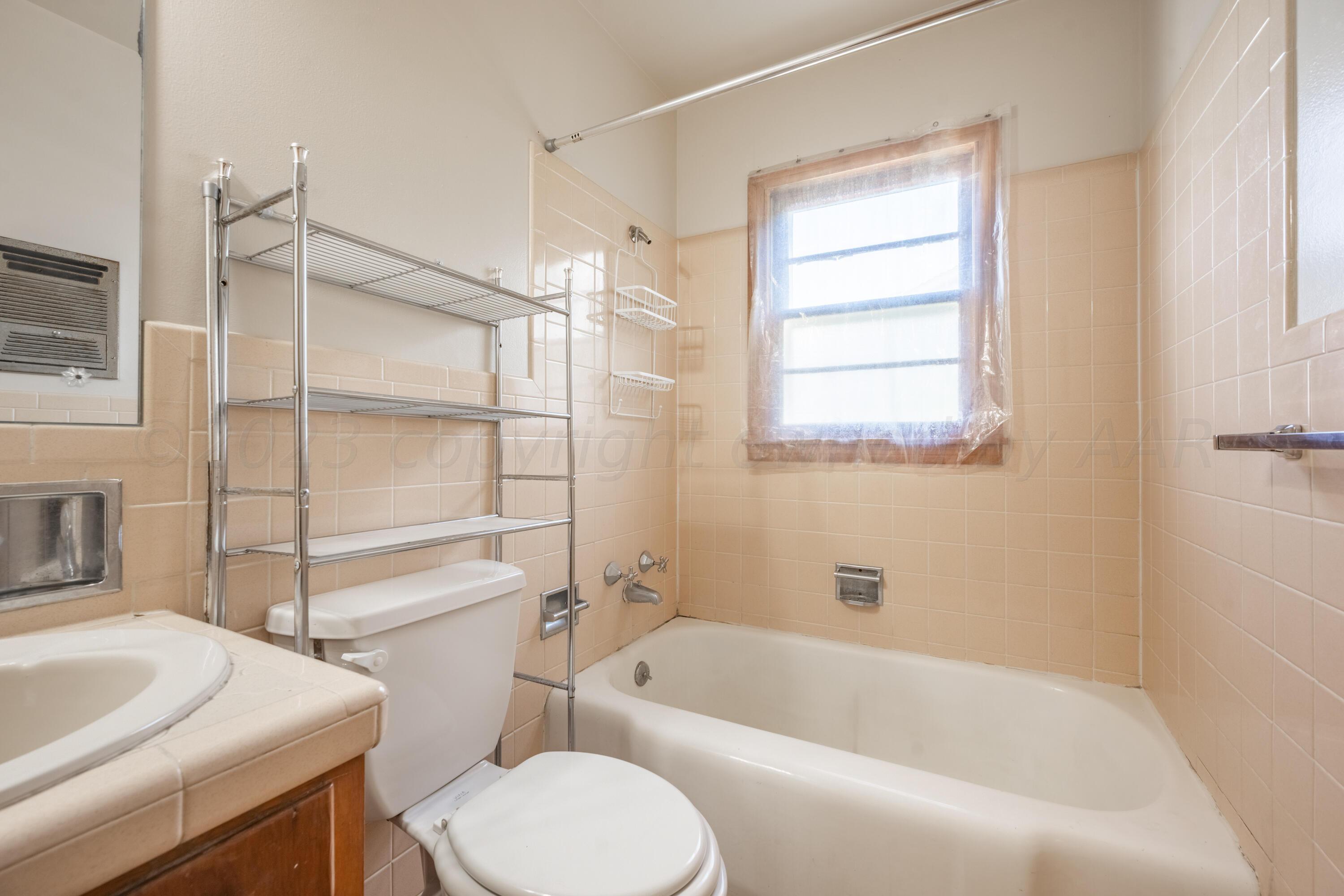 3616 South Travis Street Amarillo, TX 79110 - Photo 6 of 26 a bathroom with a sink toilet and bathtub