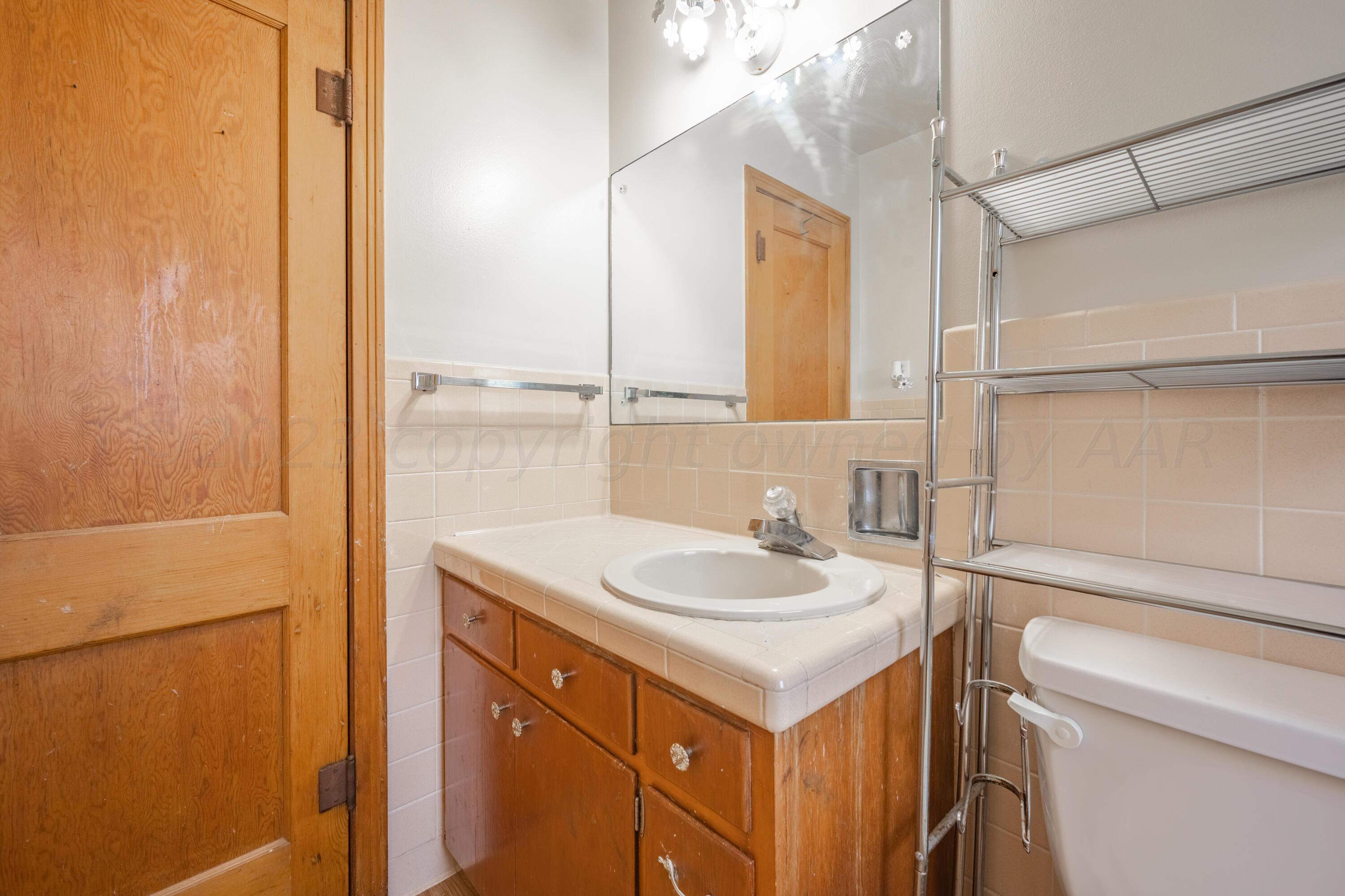 3616 South Travis Street Amarillo, TX 79110 - Photo 7 of 26 a bathroom with a sink and a mirror