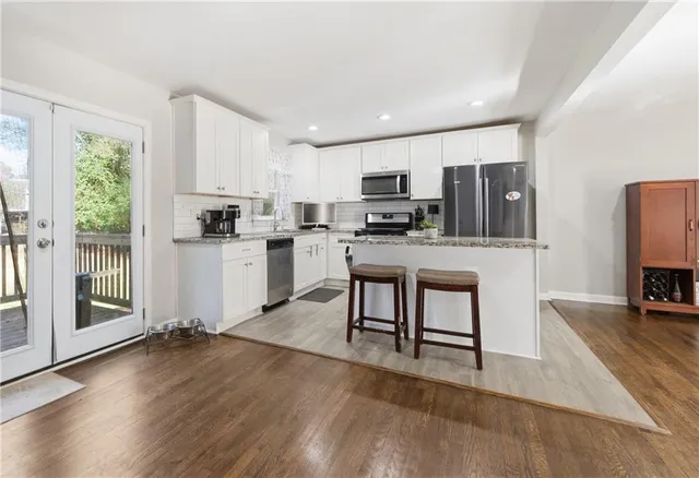a kitchen with microwave a stove top oven and cabinets