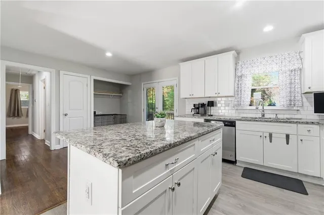 a kitchen with granite countertop kitchen island sink and cabinets