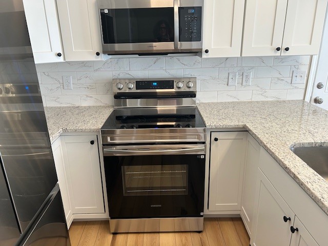 3403 Chaney Lane Clarksville, TN 37042 - Photo 6 of 28 a kitchen with granite countertop a stove top oven microwave and cabinets