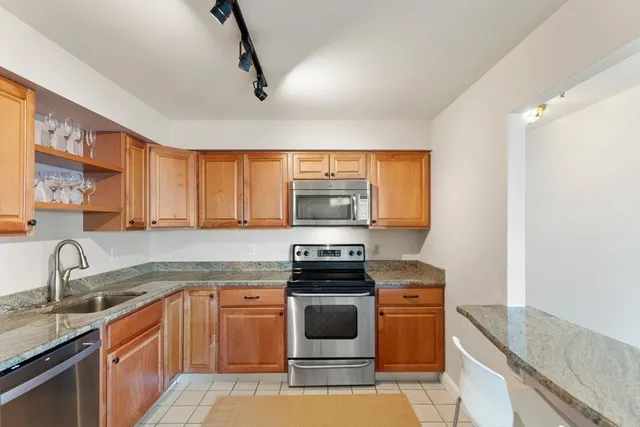 a kitchen with stainless steel appliances granite countertop a stove sink and cabinets