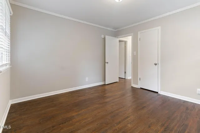 a view of an empty room with wooden floor
