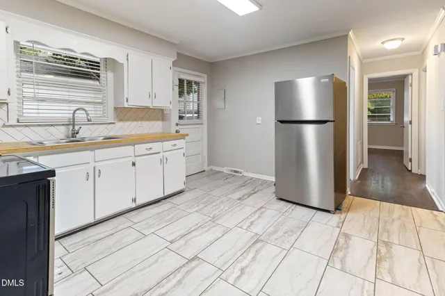 a kitchen with a sink a refrigerator and cabinets