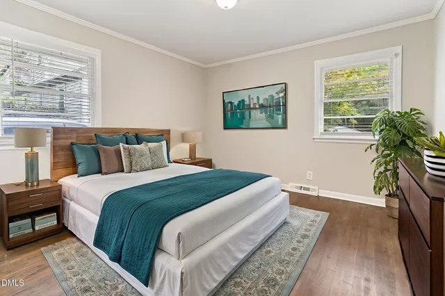 a bedroom with a large bed and a potted plant