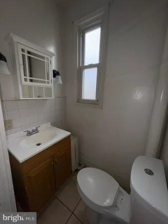 a bathroom with a toilet sink vanity and mirror