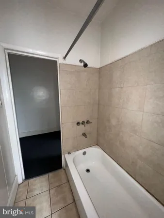 a bathroom with a tub shower and vanity