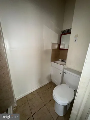 a white toilet sitting next to a sink and vanity