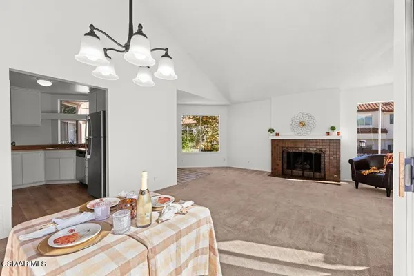 a view of a livingroom with furniture a fireplace wooden floor and a chandelier