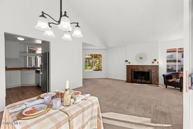 a view of a livingroom with furniture a fireplace wooden floor and a chandelier