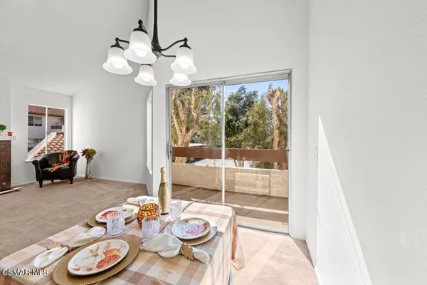 a view of a dining room with furniture wooden floor and a chandelier