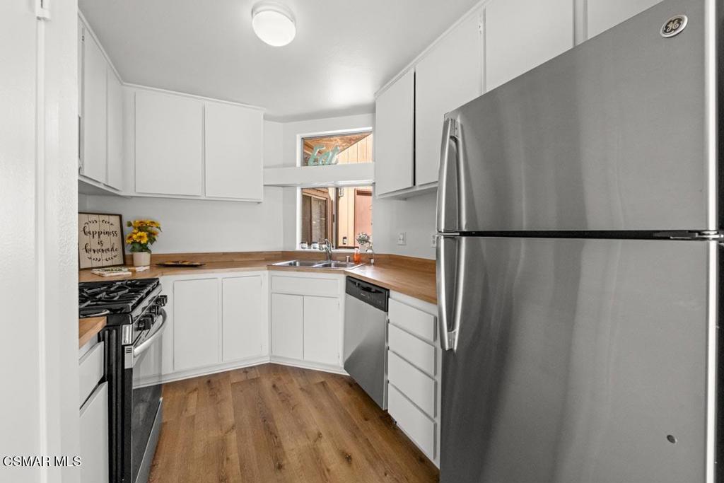 1754 Sinaloa Road, Unit 271 Simi Valley, CA 93065 - Photo 7 of 20 a kitchen with a refrigerator a stove top oven a sink and cabinets