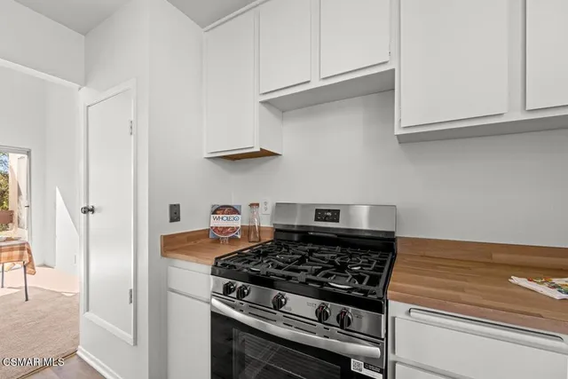 a kitchen with white cabinets and a stove