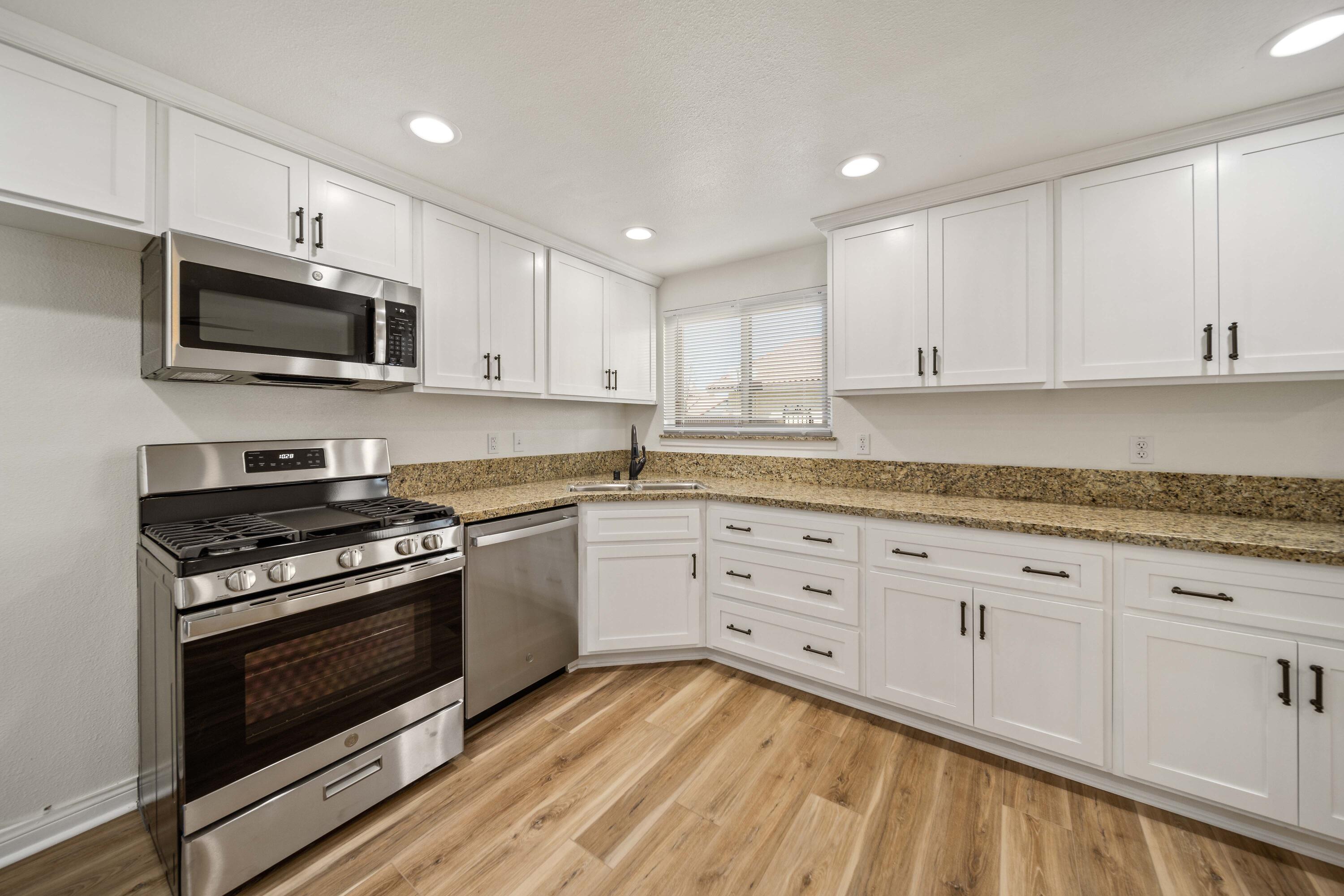 43734 Frieda Court Lancaster, CA 93535 - Photo 12 of 32 a kitchen with granite countertop white cabinets and stainless steel appliances