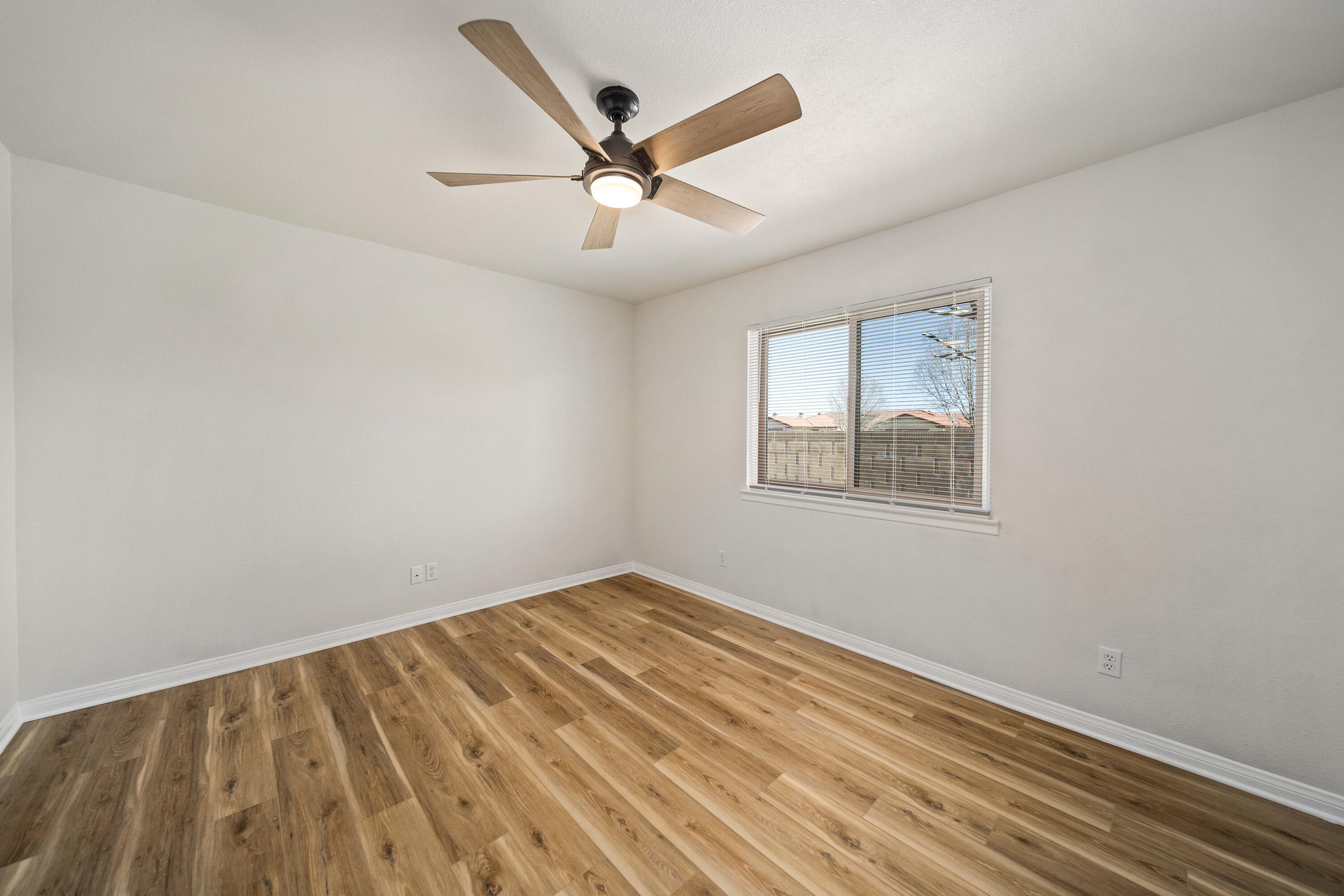 43734 Frieda Court Lancaster, CA 93535 - Photo 18 of 32 an empty room with wooden floor ceiling fan and windows