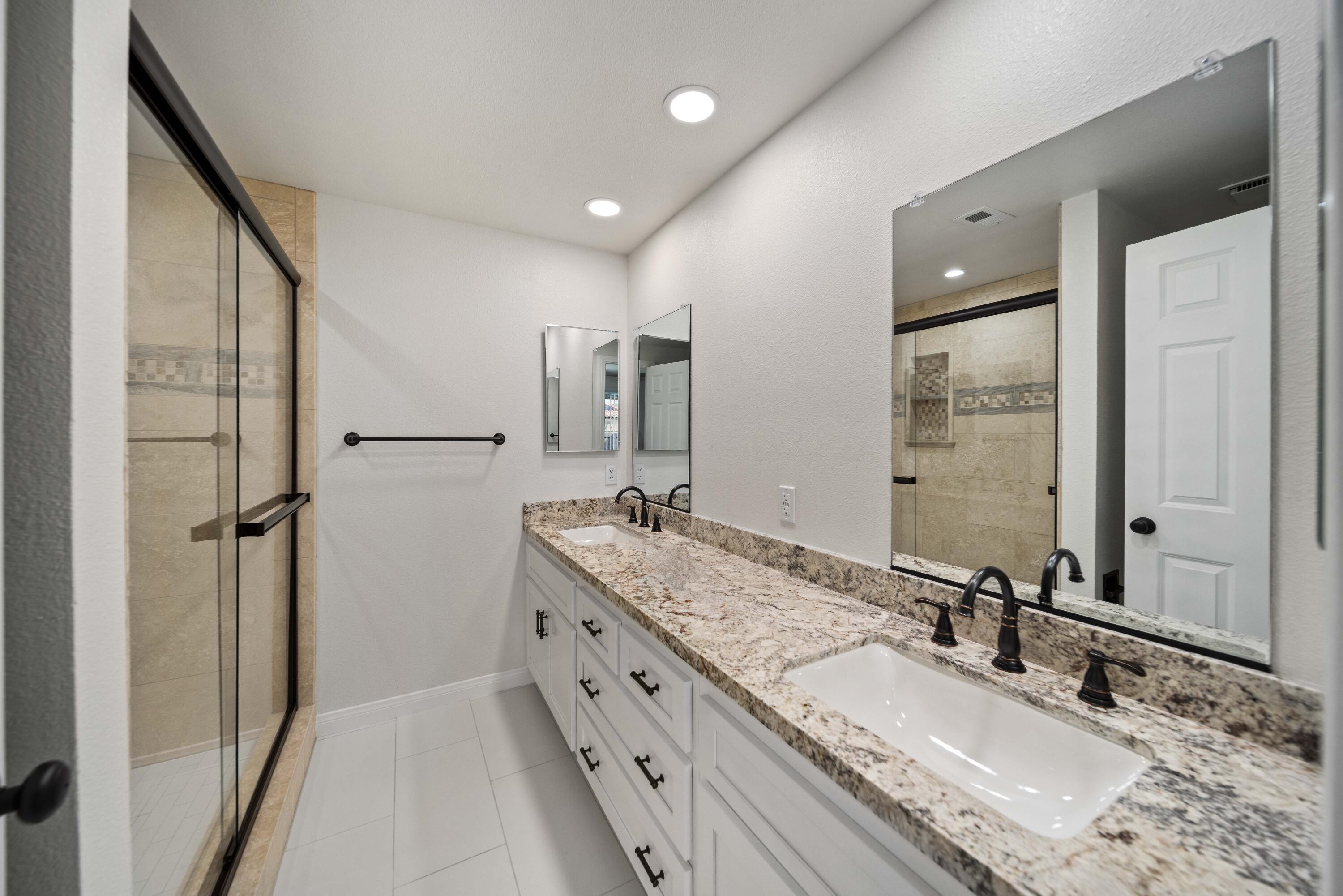 43734 Frieda Court Lancaster, CA 93535 - Photo 24 of 32 a bathroom with a granite countertop double vanity sink and mirror