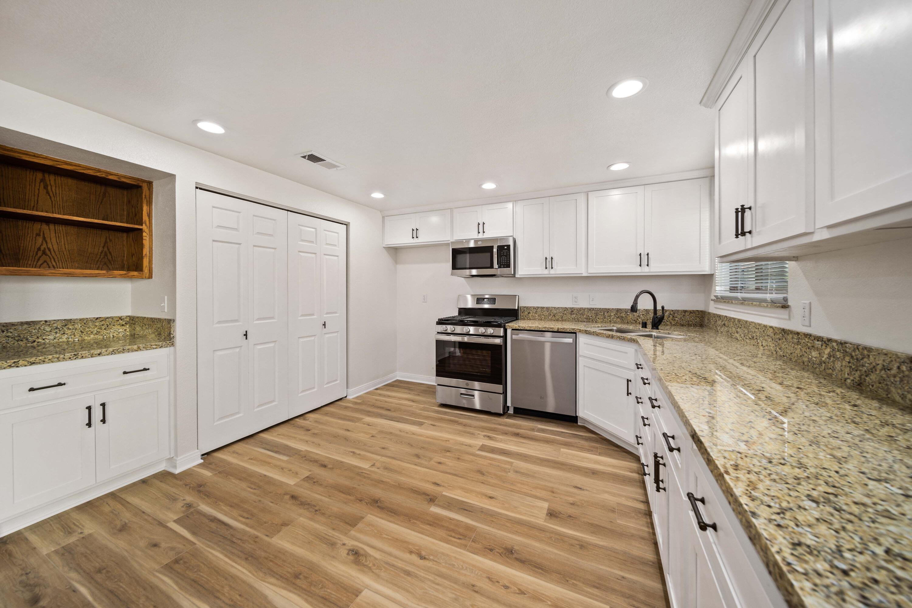 43734 Frieda Court Lancaster, CA 93535 - Photo 10 of 32 a kitchen with granite countertop white cabinets and stainless steel appliances