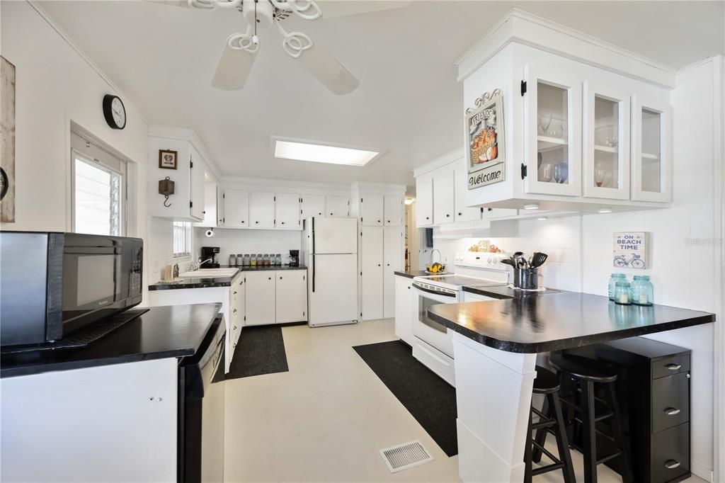 10303 Burnt Store Road, Unit 221 Punta Gorda, FL 33950 - Photo 3 of 31 a kitchen with stainless steel appliances kitchen island granite countertop a sink and cabinets