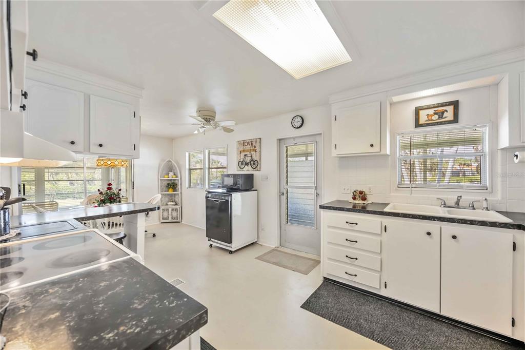 10303 Burnt Store Road, Unit 221 Punta Gorda, FL 33950 - Photo 4 of 31 a kitchen with granite countertop a sink cabinets stainless steel appliances and a window
