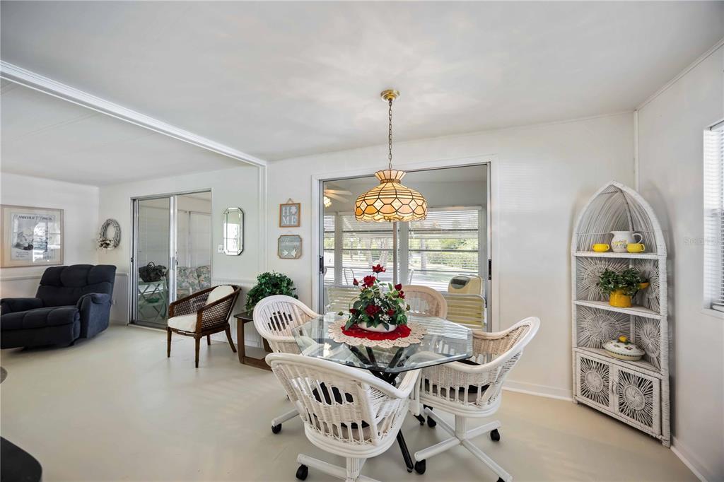 10303 Burnt Store Road, Unit 221 Punta Gorda, FL 33950 - Photo 5 of 31 a view of a dining room with furniture a chandelier and window