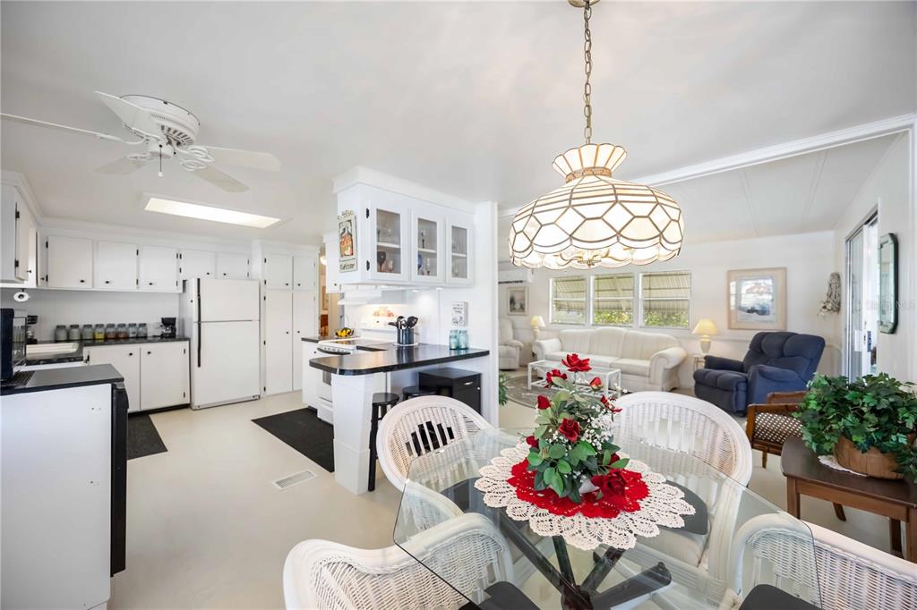 10303 Burnt Store Road, Unit 221 Punta Gorda, FL 33950 - Photo 7 of 31 a living room with kitchen island furniture and a chandelier