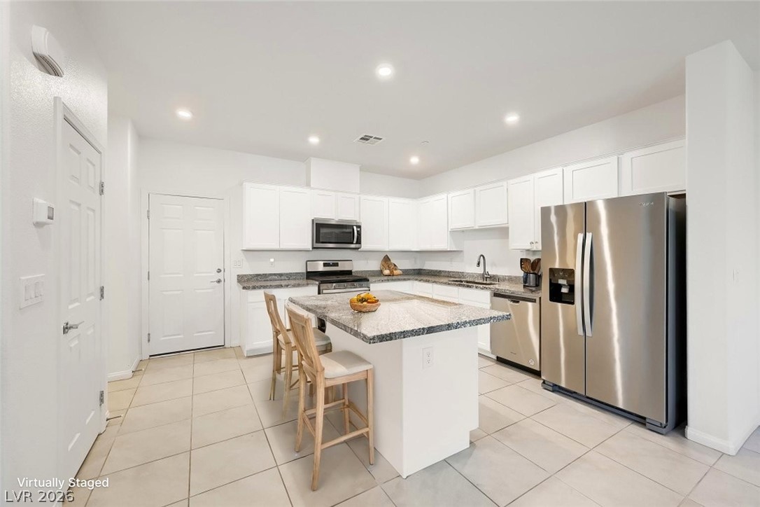 489 Filaree Place Henderson, NV 89015 - Photo 4 of 36 Sleek kitchen with large island & ample seating - Virtually Staged