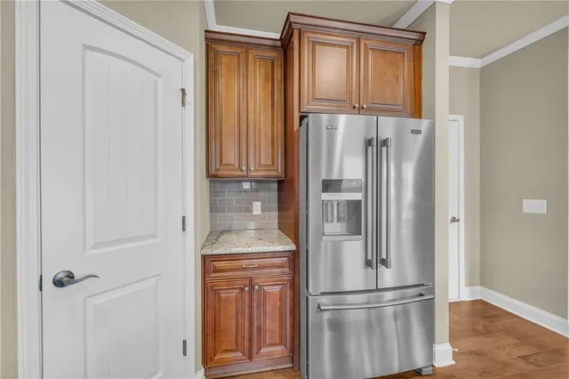 a metallic refrigerator freezer and a wooden door