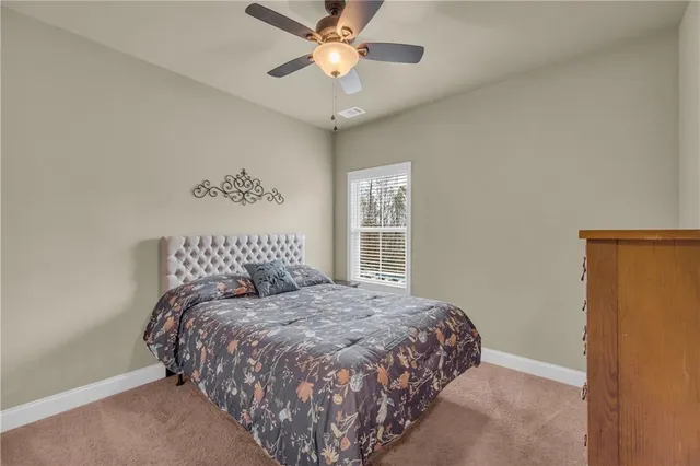 a large bed sitting in a bedroom next to a window and a chandelier