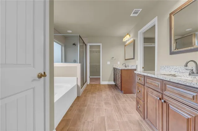 a bathroom with a granite countertop sink mirror and cabinets