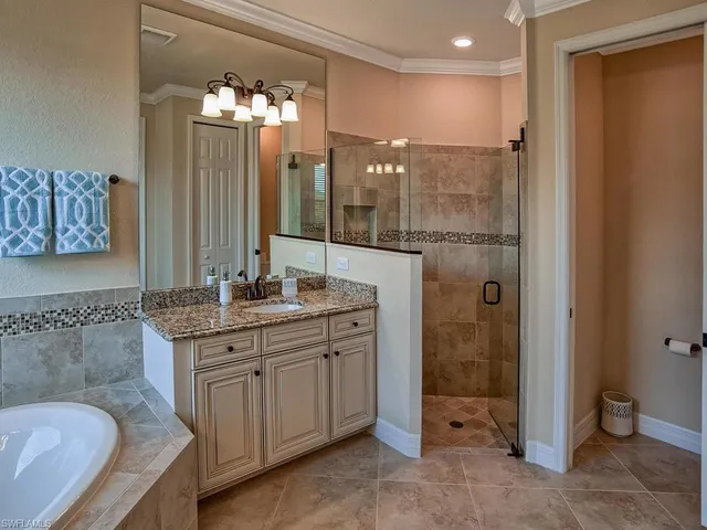 a bathroom with a granite countertop sink a toilet a mirror and shower
