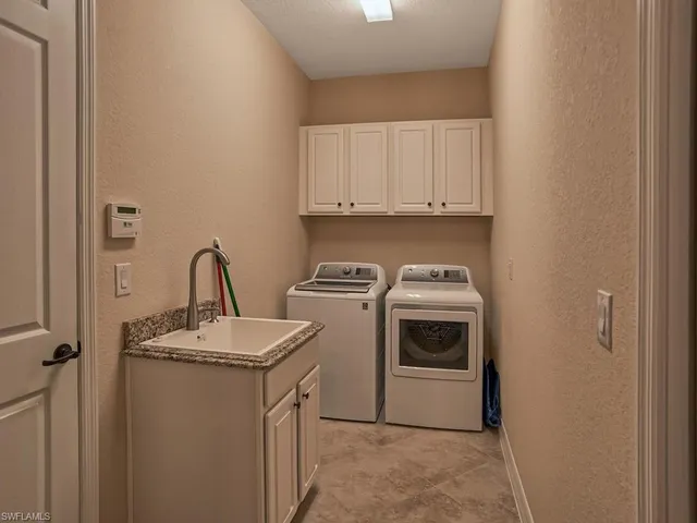 a utility room with sink dryer and washer