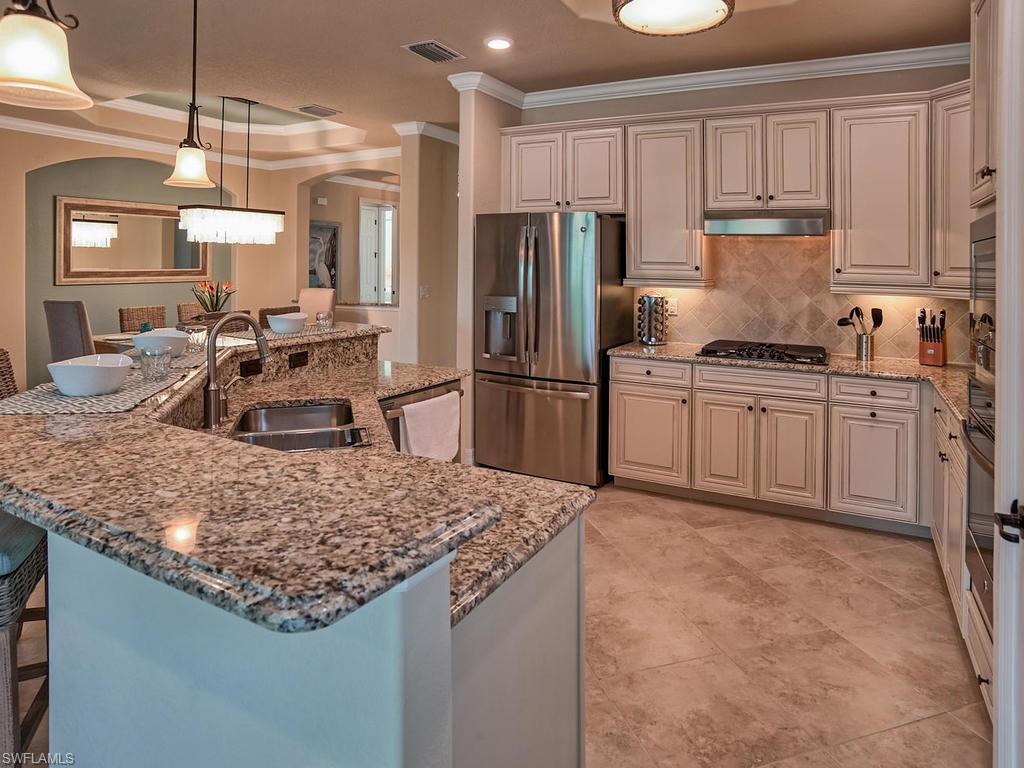 2850 Aviamar Circle Naples, FL 34114 - Photo 8 of 26 a kitchen with stainless steel appliances granite countertop a sink stove and refrigerator