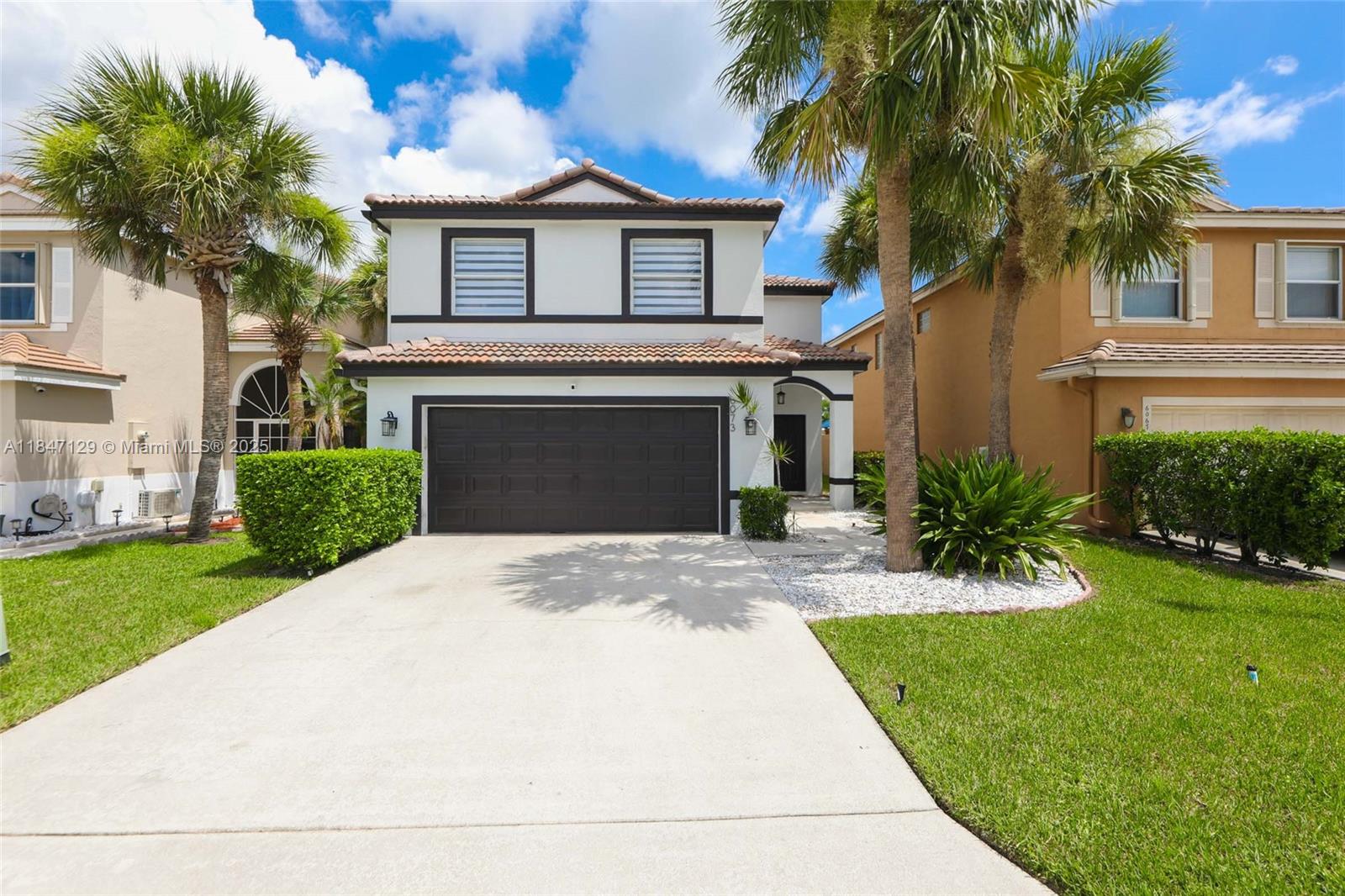 a front view of a house with a yard and garage